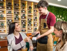 a waiter helping a woman with her transaction
